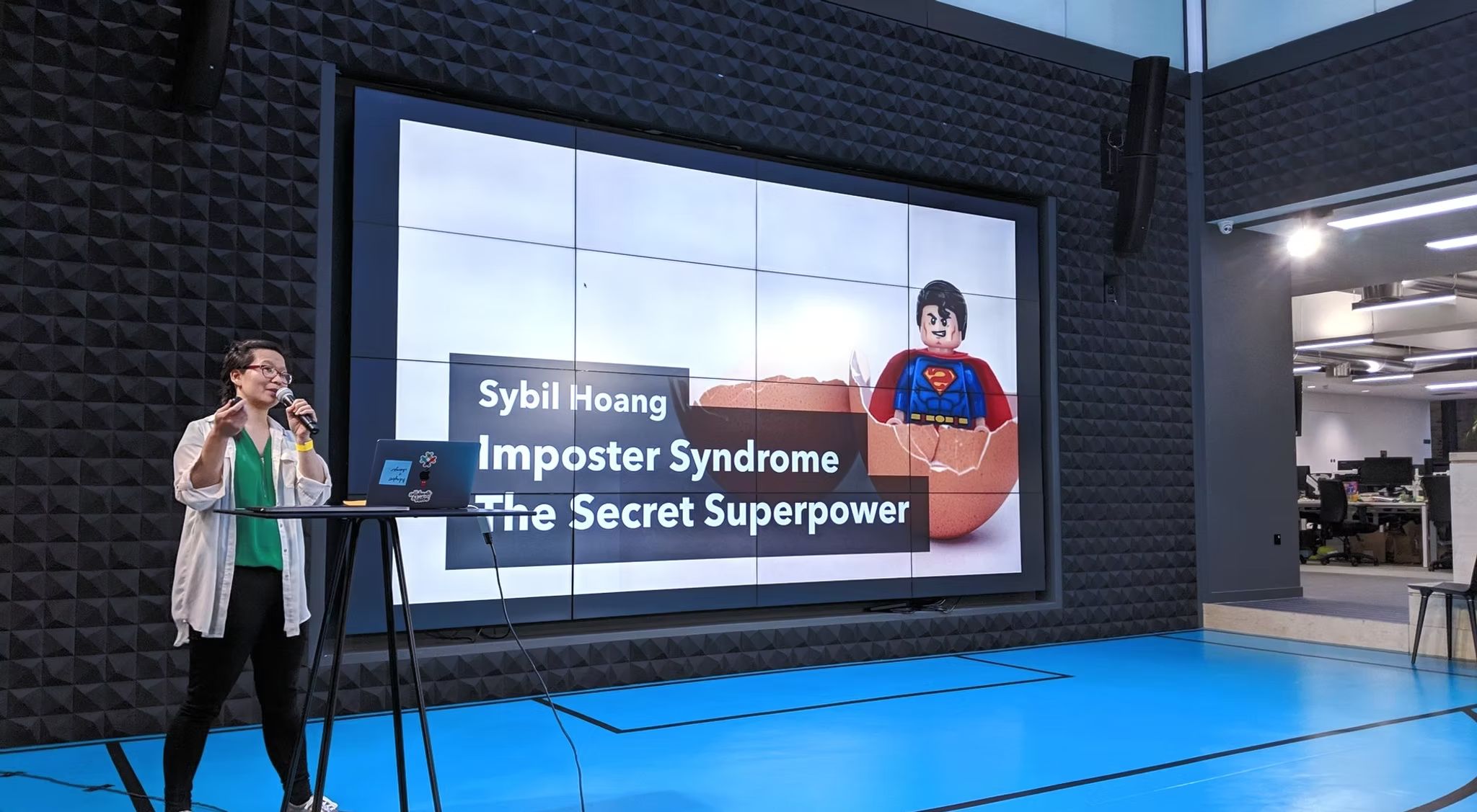 Sybil Hoang speaking at an event, Imposter Syndrome: The Secret Superpower